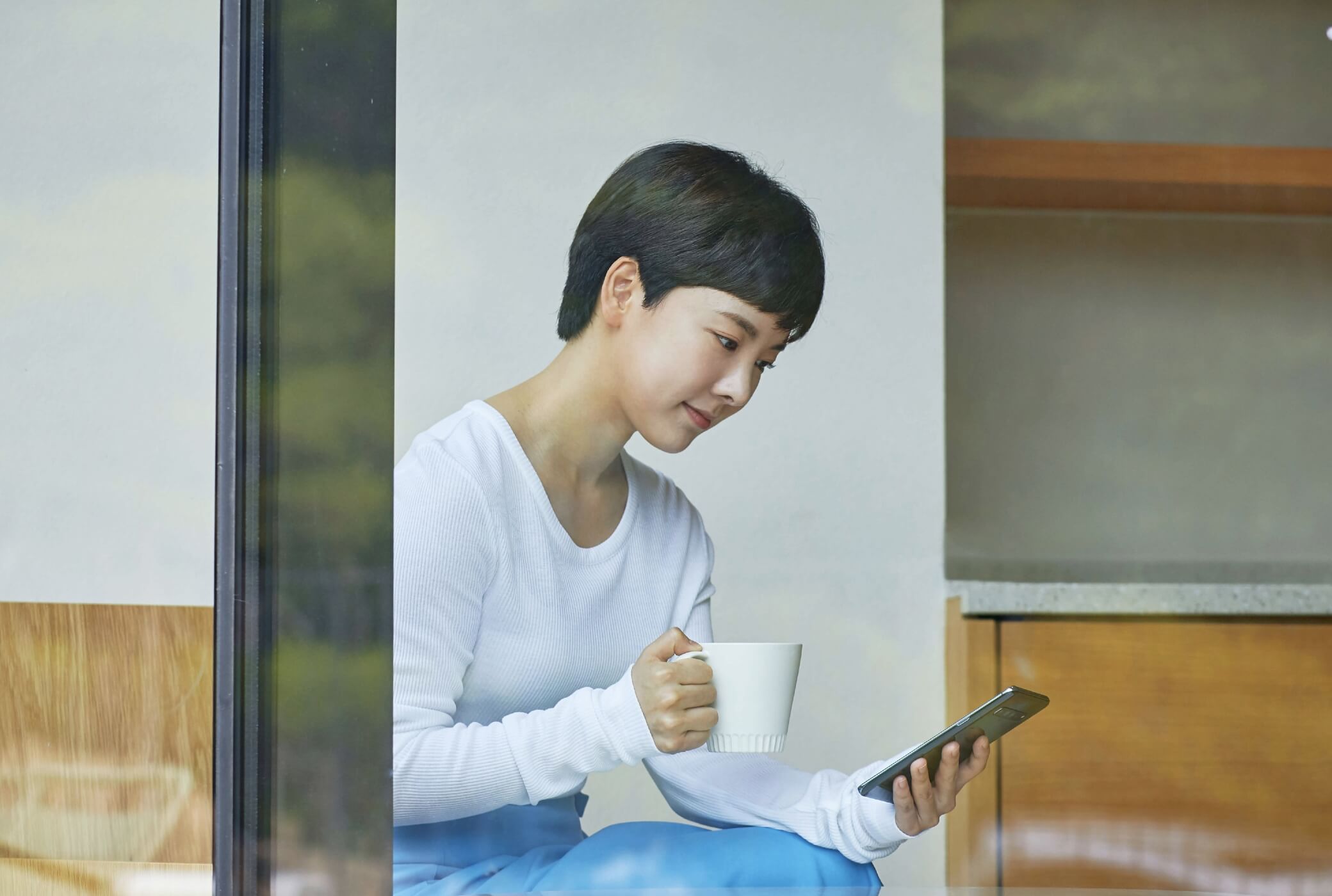 women use smartphone with a coffee